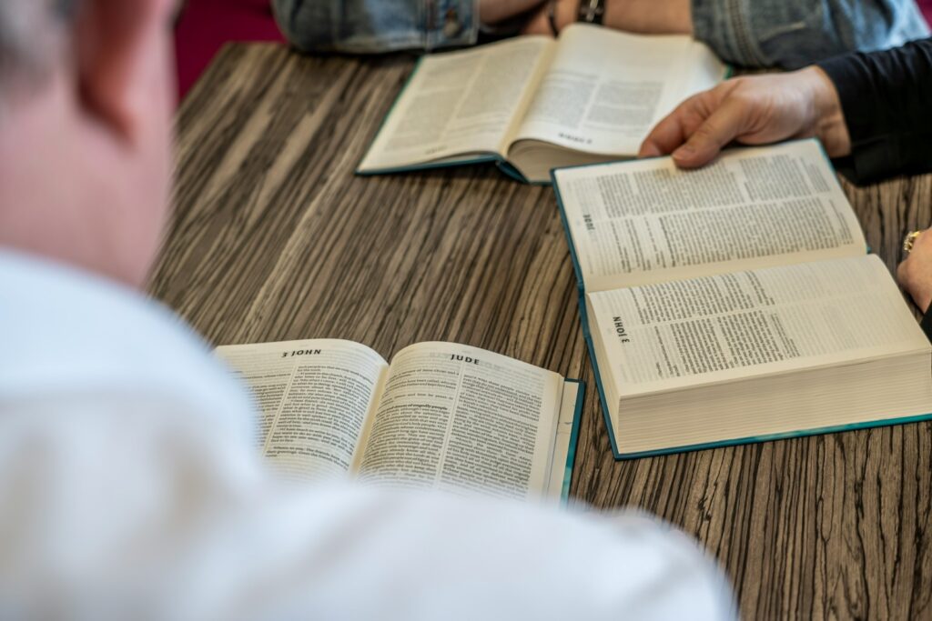 two people sitting at a table with open books